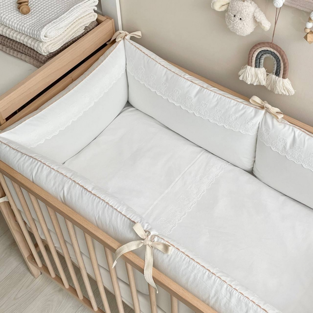 Babybett mit weichem Bettwäsche-Set in Milchweiß, harmonisch in einem modernen Kinderzimmer dekoriert