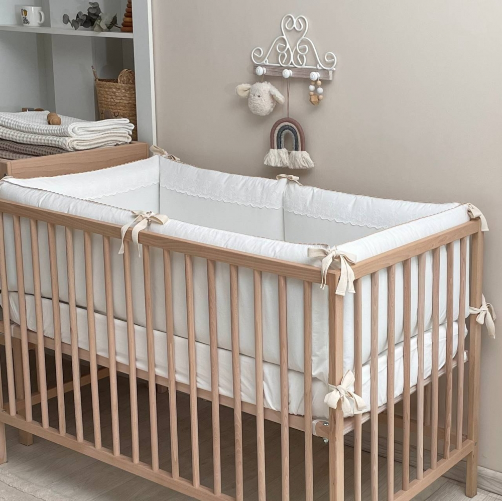 Kleines Babybett im gemütlichen Raum, komplett mit Teddy-Motiv Bettwäsche-Set.