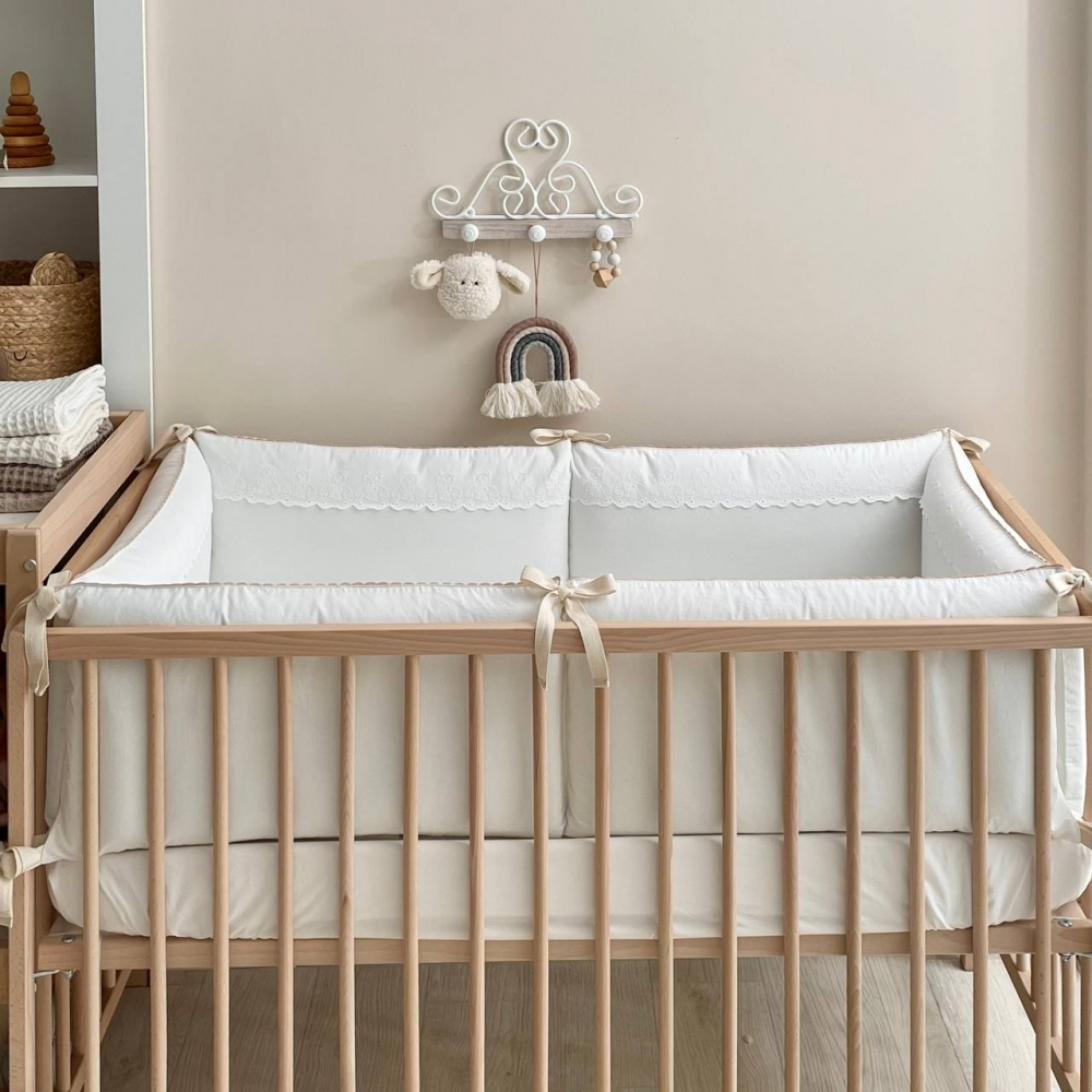 Kinderzimmer mit Babybett und stilvollem Bettwäsche-Set, das eine warme und einladende Atmosphäre schafft