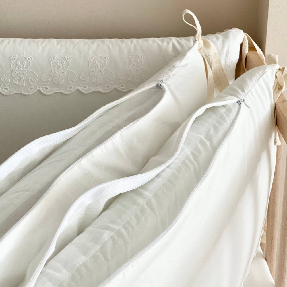 Babybett Bettwäsche-Set für Neugeborene, aus 100% natürlicher, hypoallergener Baumwolle gefertigt, ideal für empfindliche Haut, mit einem süßen Teddy-Motiv in Milchweiß. Das Set umfasst einen Deckenbezug, Kissenbezug, Spannbettlaken und Bumper für das Bab